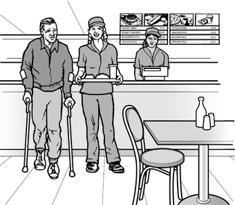 In a casual restaurant, an employee assists a man using crutches, by carrying his tray to a table